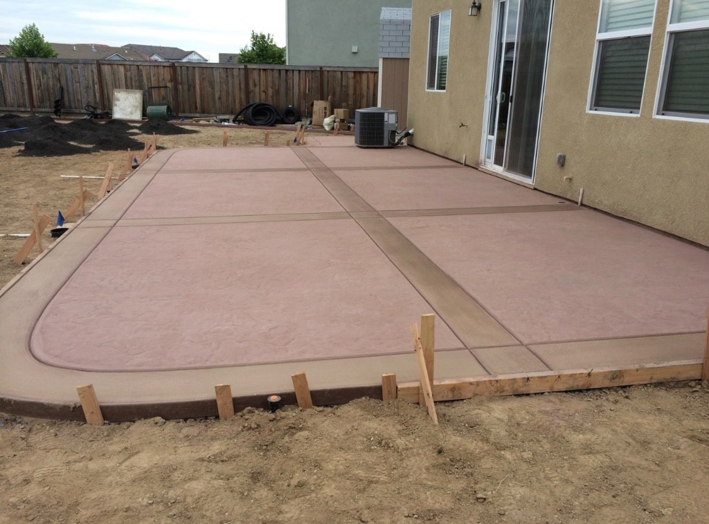 Freshly poured stamped concrete backyard patio under construction