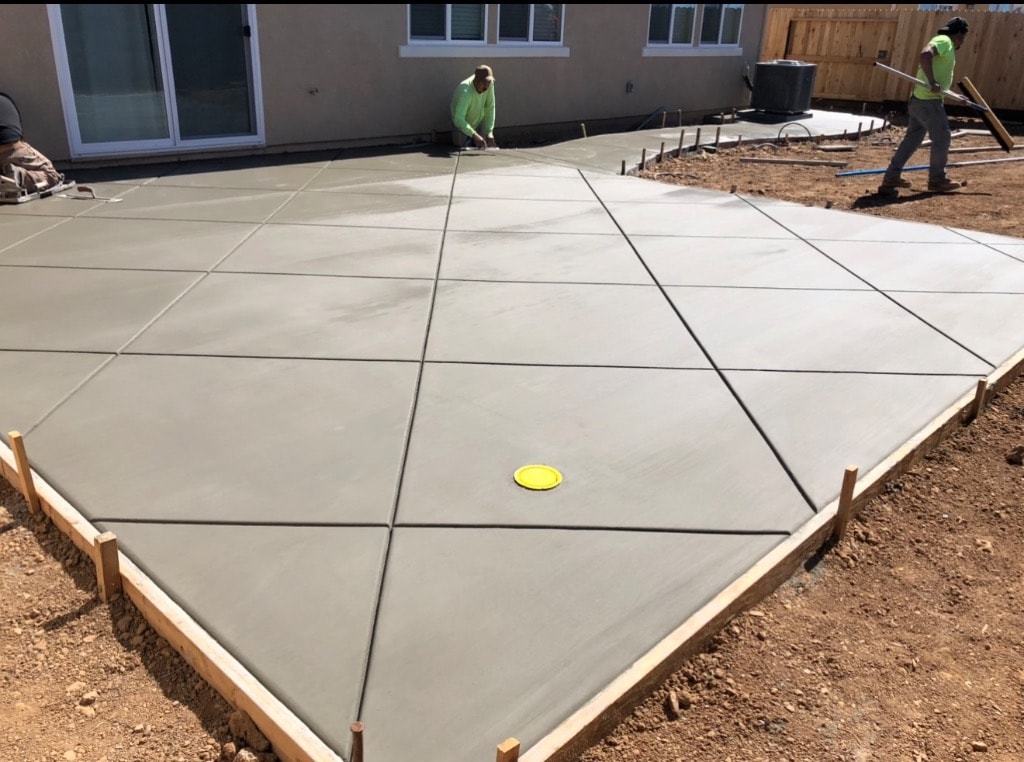 Workers pouring concrete patio slab